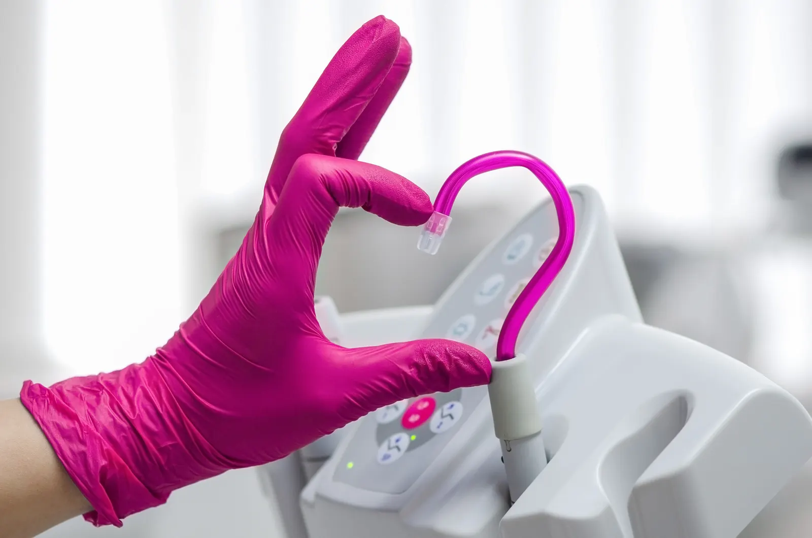 Dental professional holding a modern curing-light handpiece at a treatment chair