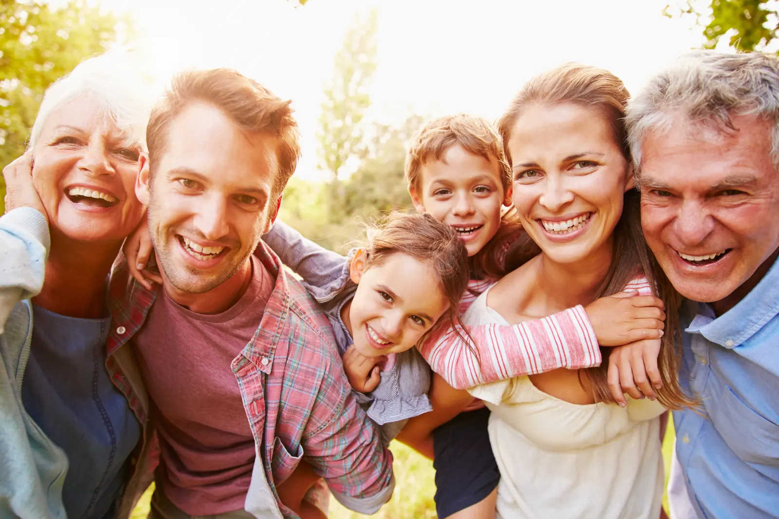 Three generations of a family laughing outdoors