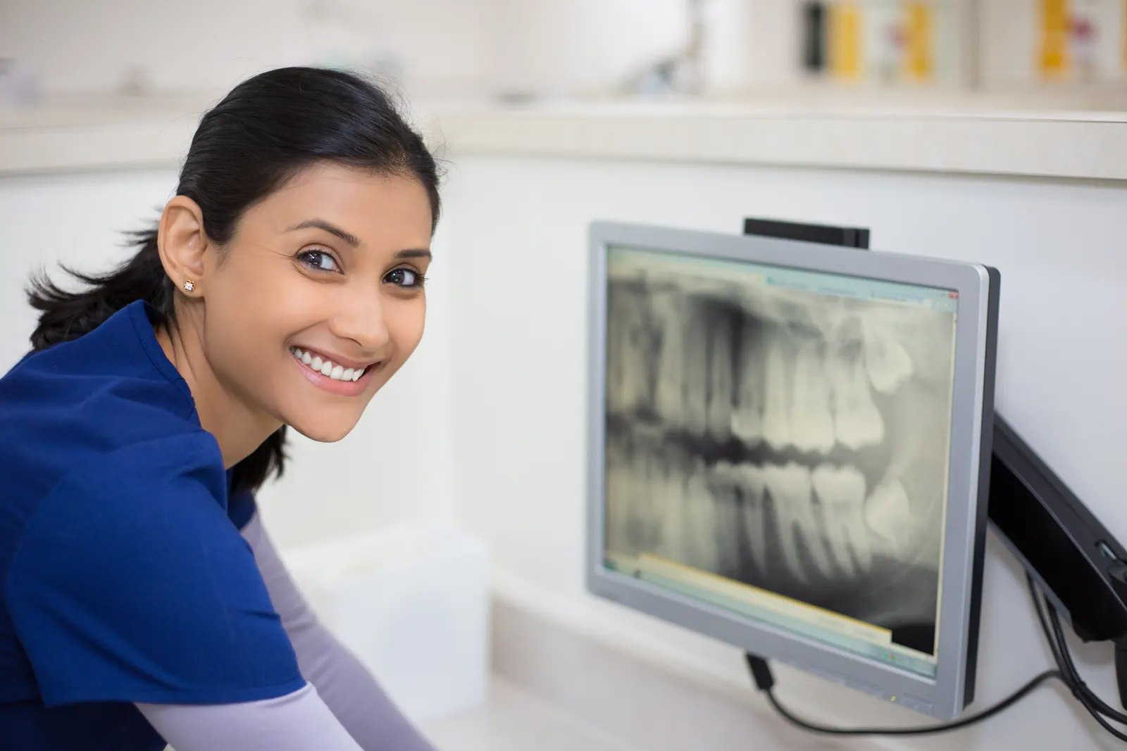 Dentist reviewing a dental X-ray on a monitor